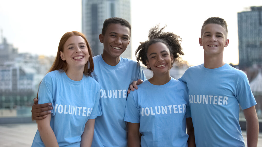Group of diverse volunteers smiling together outdoors.
