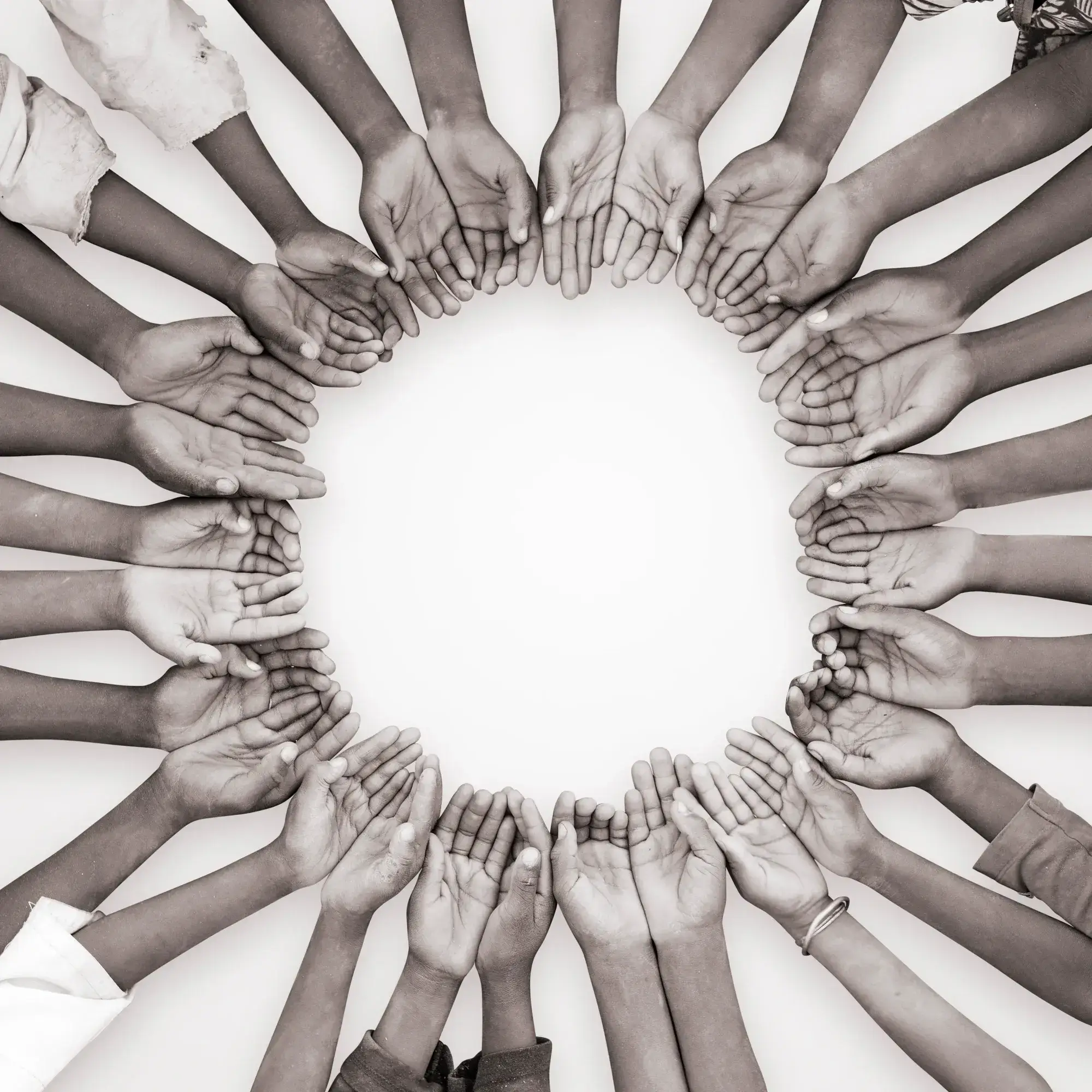 Circle of hands holding small burlap bags with grain.
